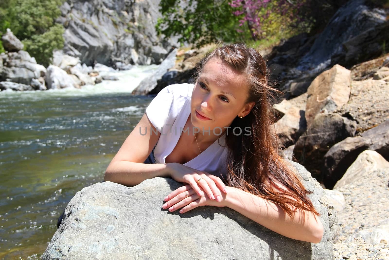 Beautiful girl on coastline river in Yosemite National Park