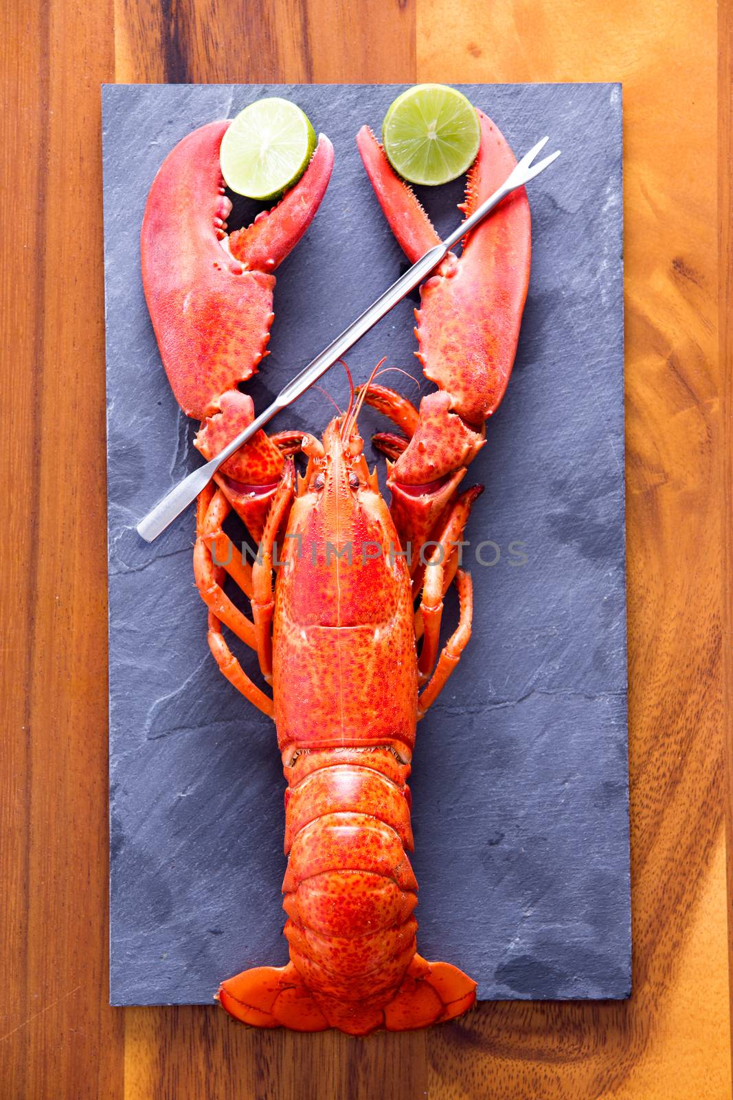 Lobster Clipping Limes on Cutting Board with Picks by coskun