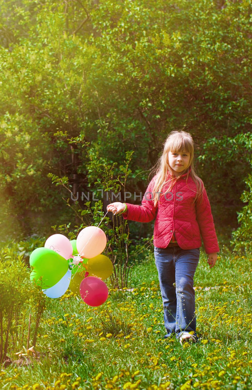 Outdoor portrait of a cute young  little girl playing with balloons