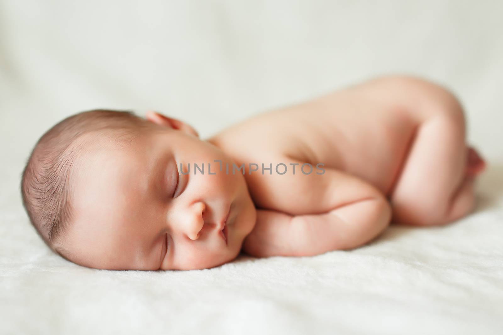 a beautiful sweet newborn baby sleeping on a blanket