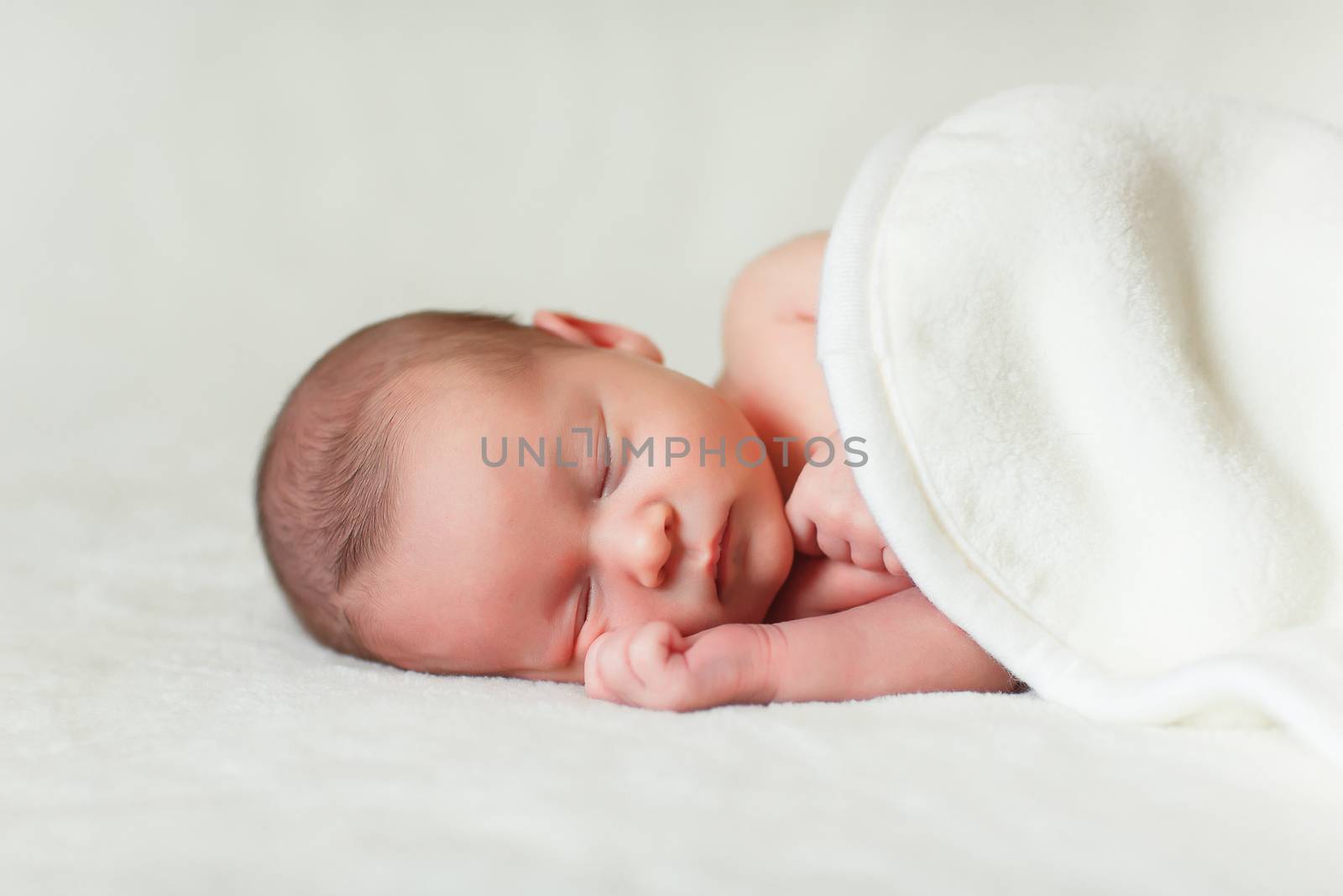 a beautiful sweet newborn baby sleeping on a blanket