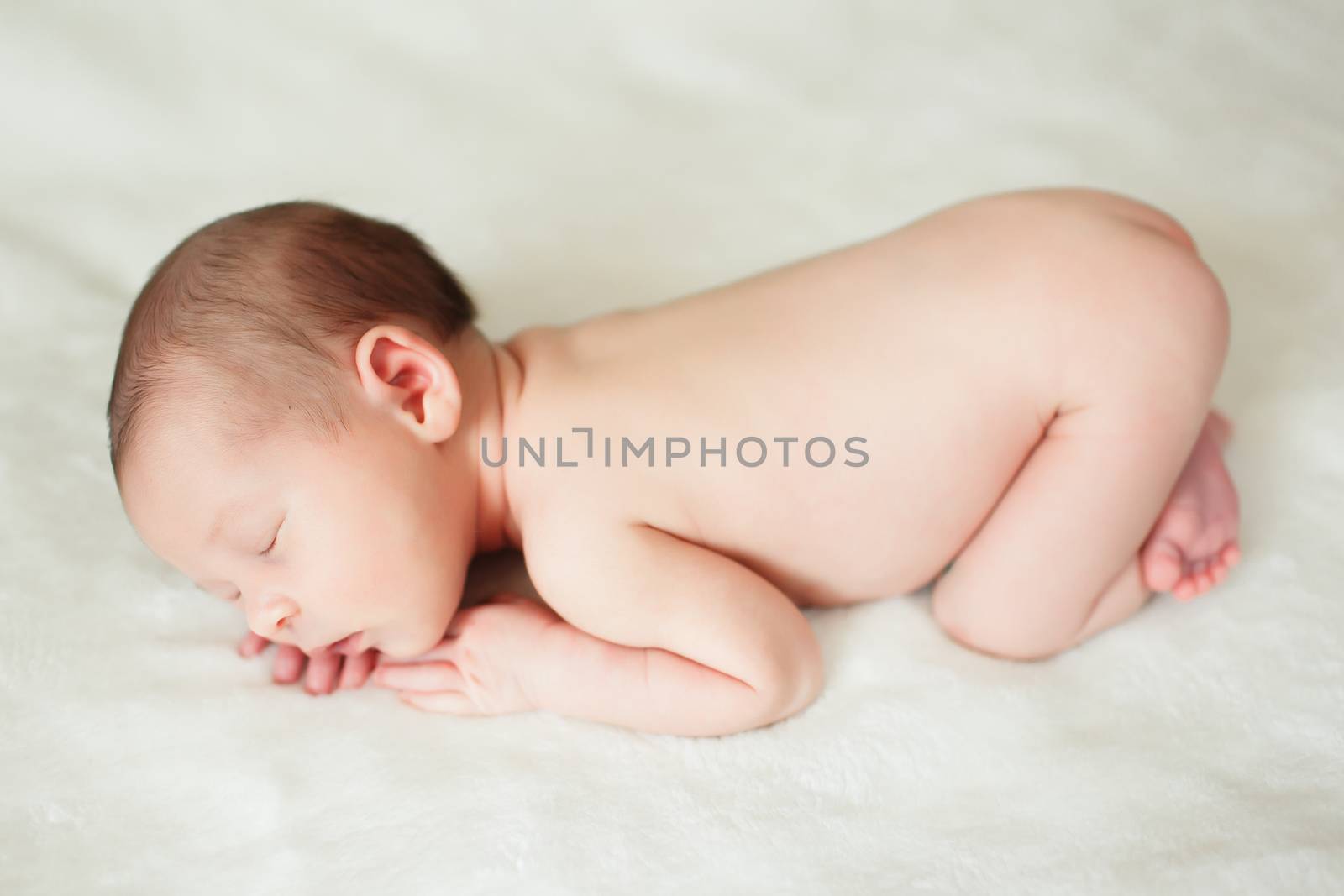 a beautiful sweet newborn baby sleeping on a blanket