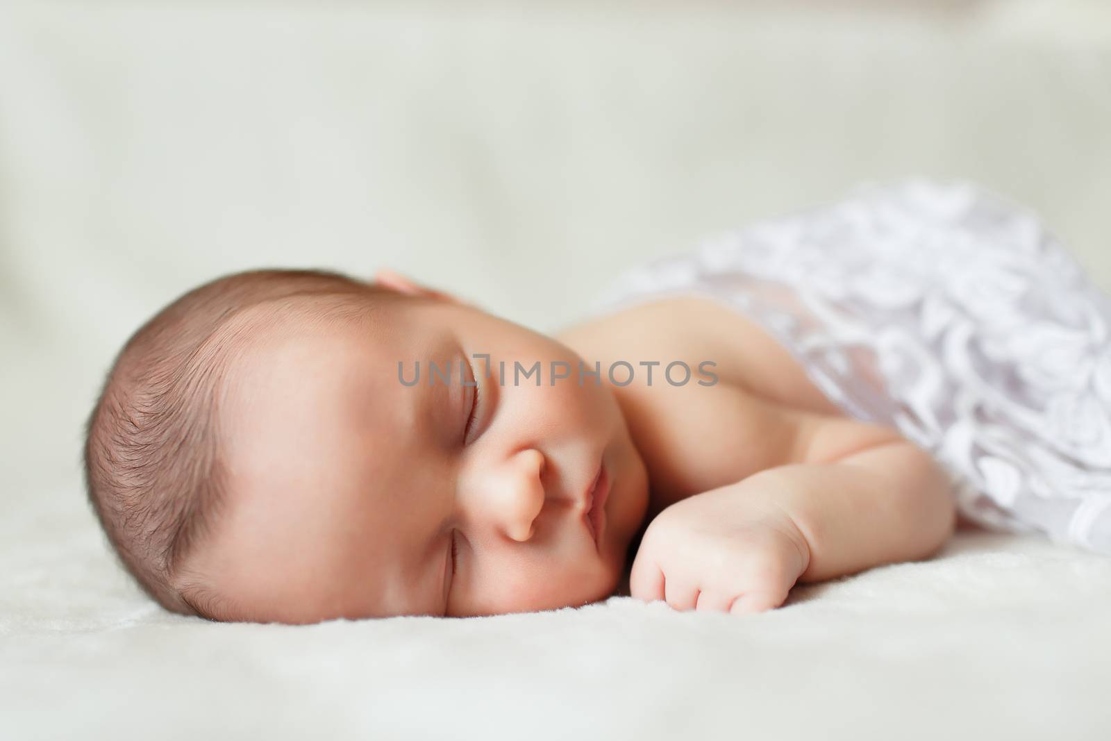 a beautiful sweet newborn baby sleeping on a blanket