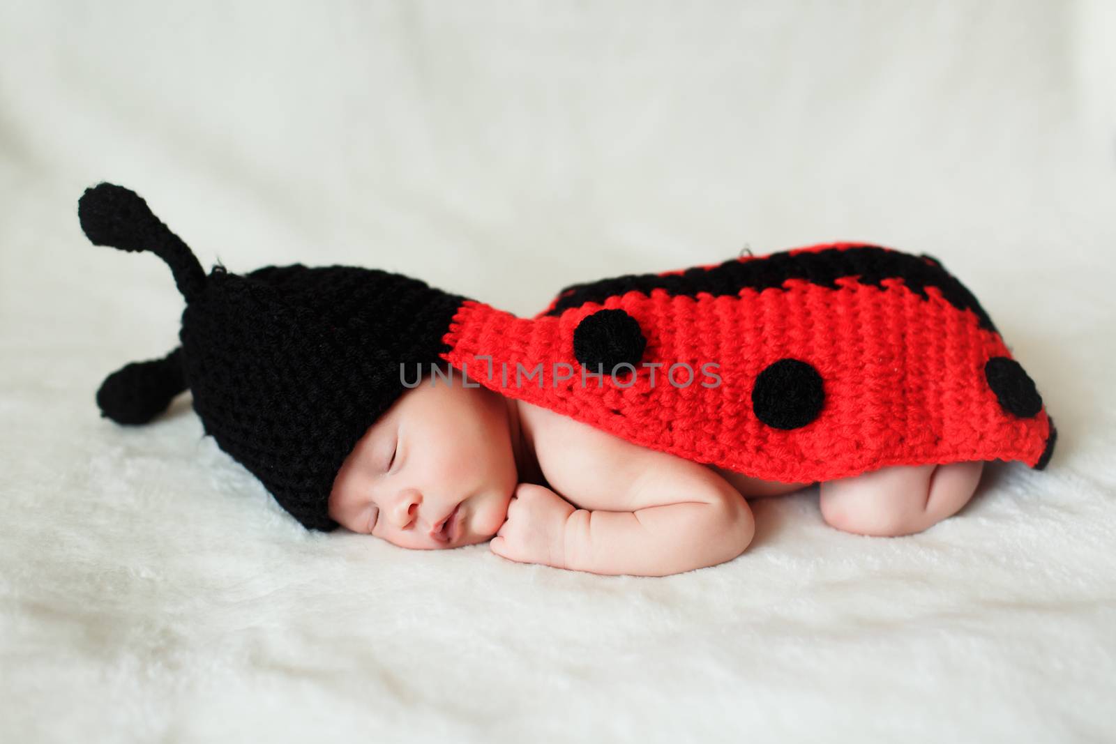 a beautiful sweet newborn baby sleeping on a blanket