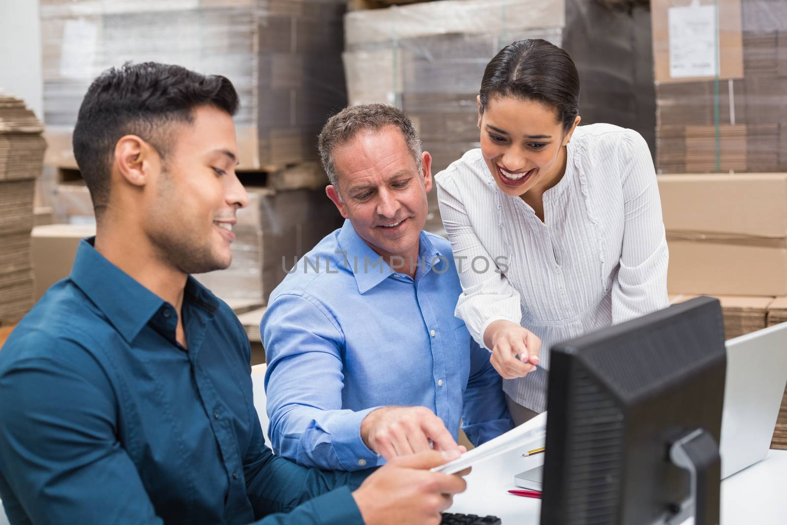 Warehouse team working together with clipboard in a large warehouse