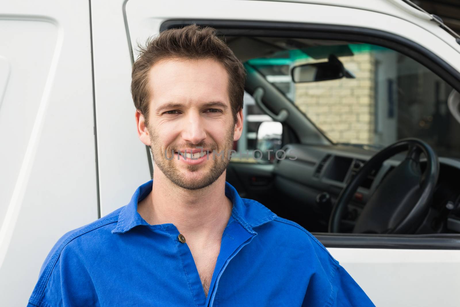 Portrait of smiling man standing in front of delivery van