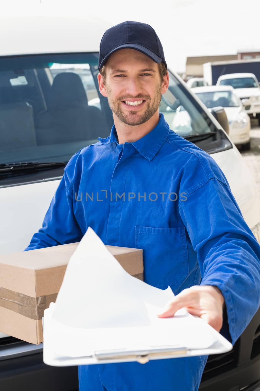 Delivery man showing clipboard to sign to customer outside the warehouse