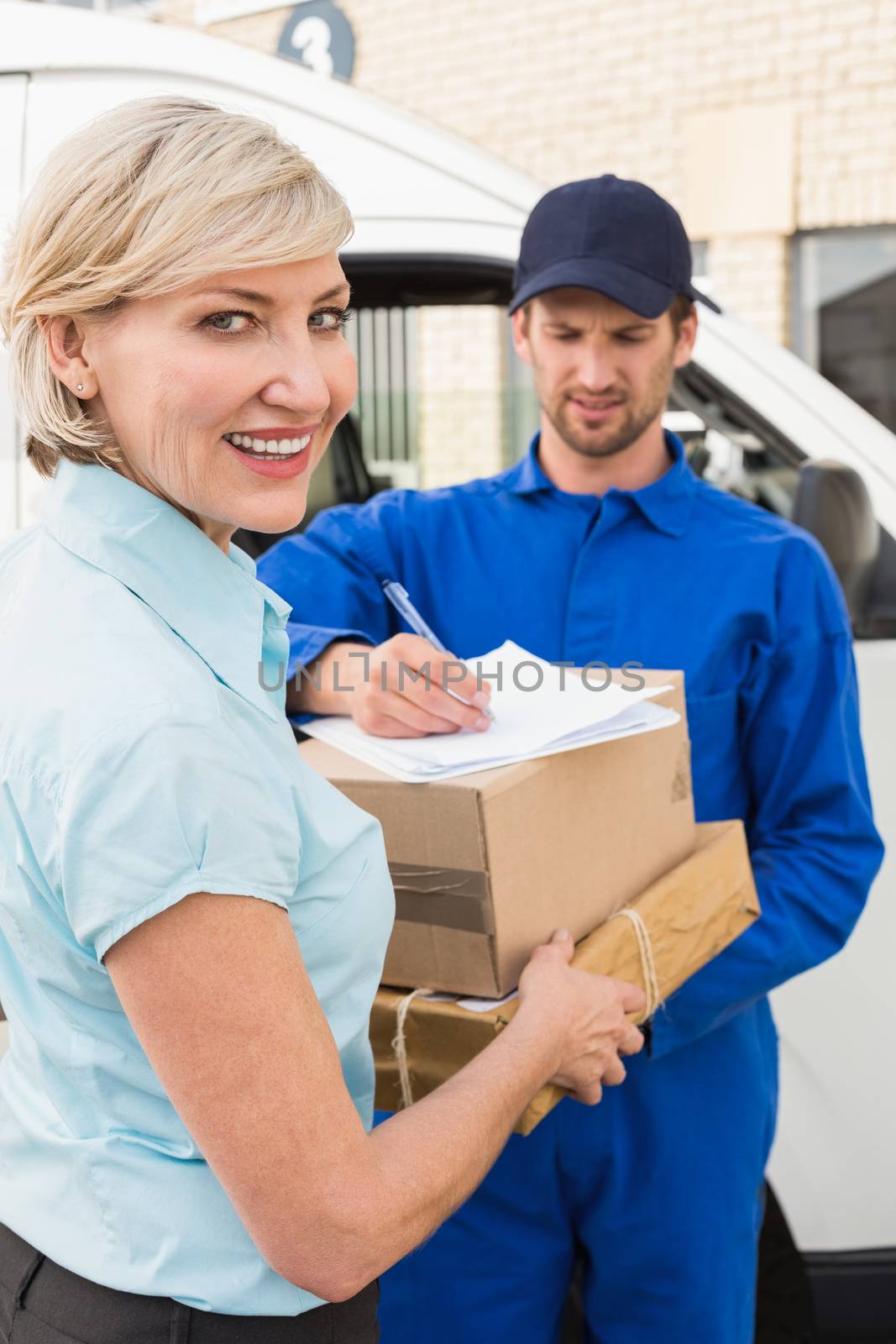 Happy delivery man with customer by Wavebreakmedia