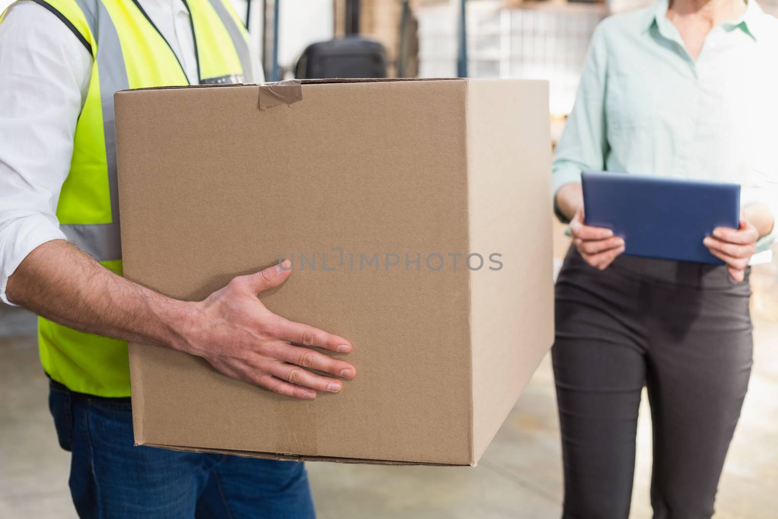 Close up of a warehouse worker carrying box by Wavebreakmedia