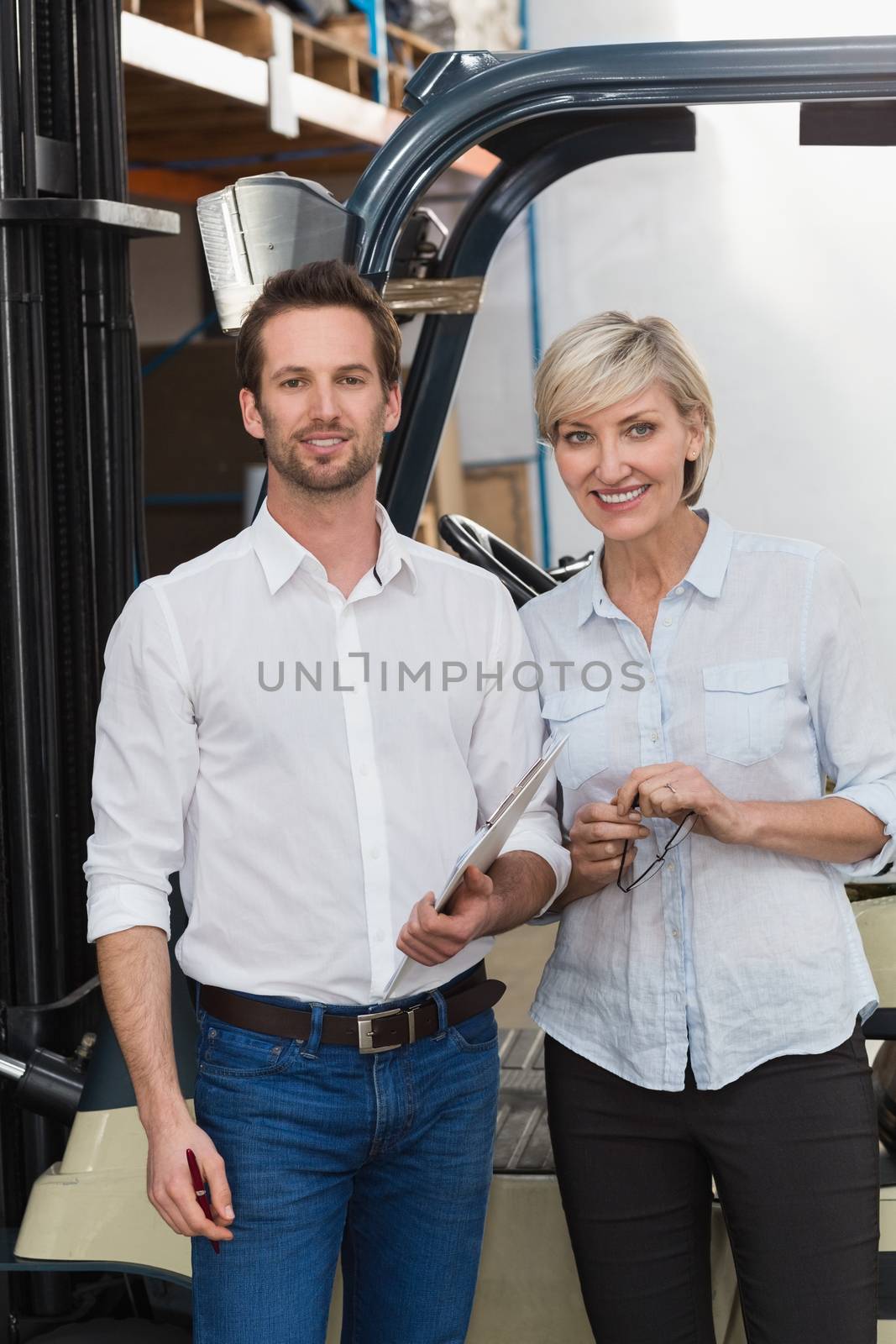 Smiling warehouse managers looking at camera by Wavebreakmedia