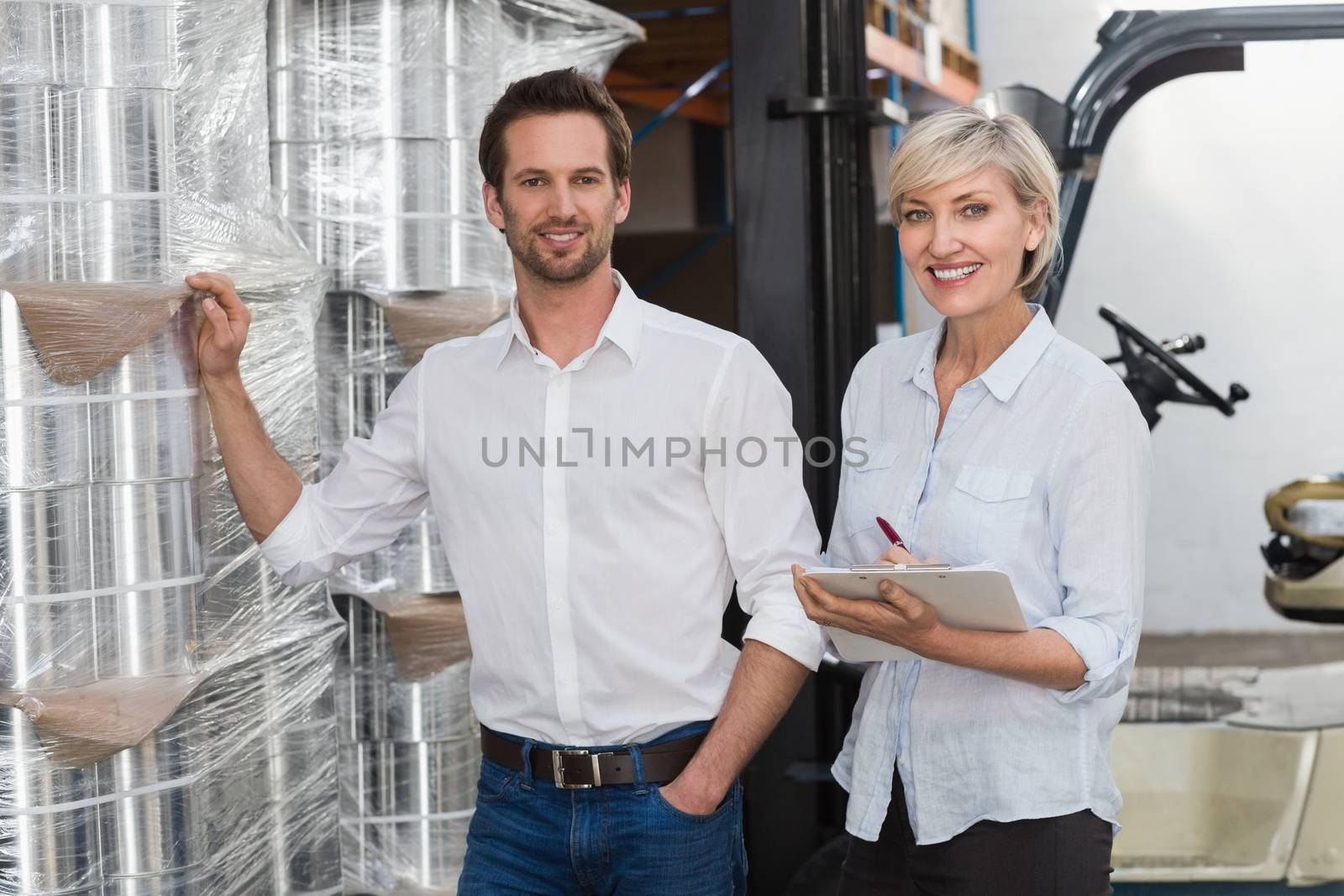 Smiling warehouse managers checking inventory by Wavebreakmedia