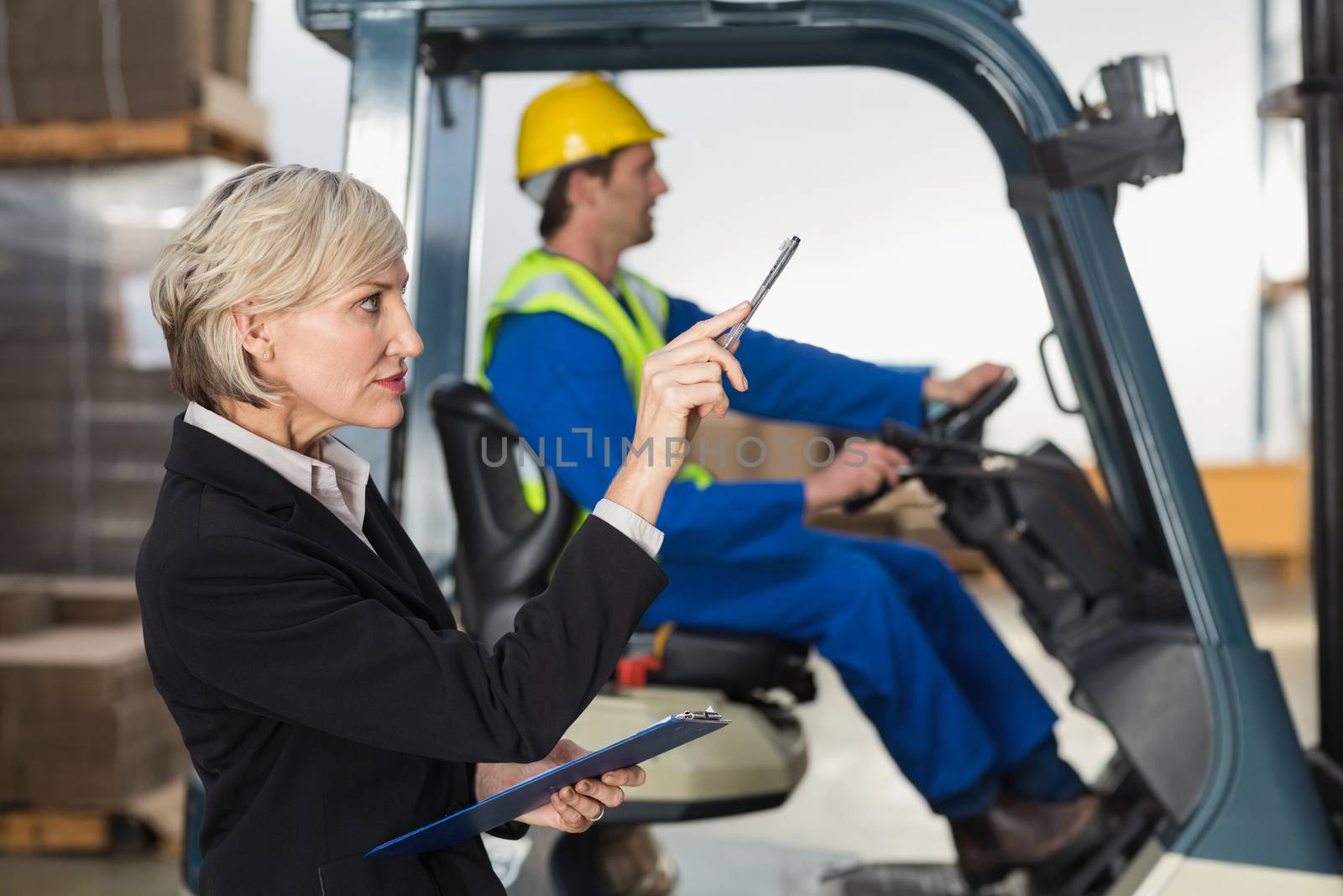 Warehouse manager checking her inventory in a large warehouse