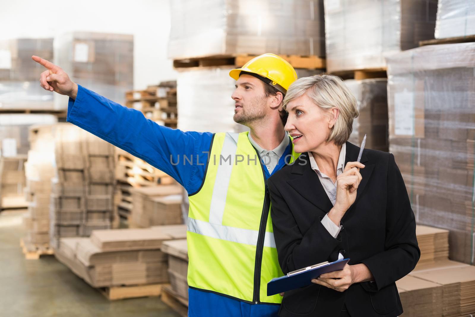 Warehouse worker and his manager working together in a large warehouse