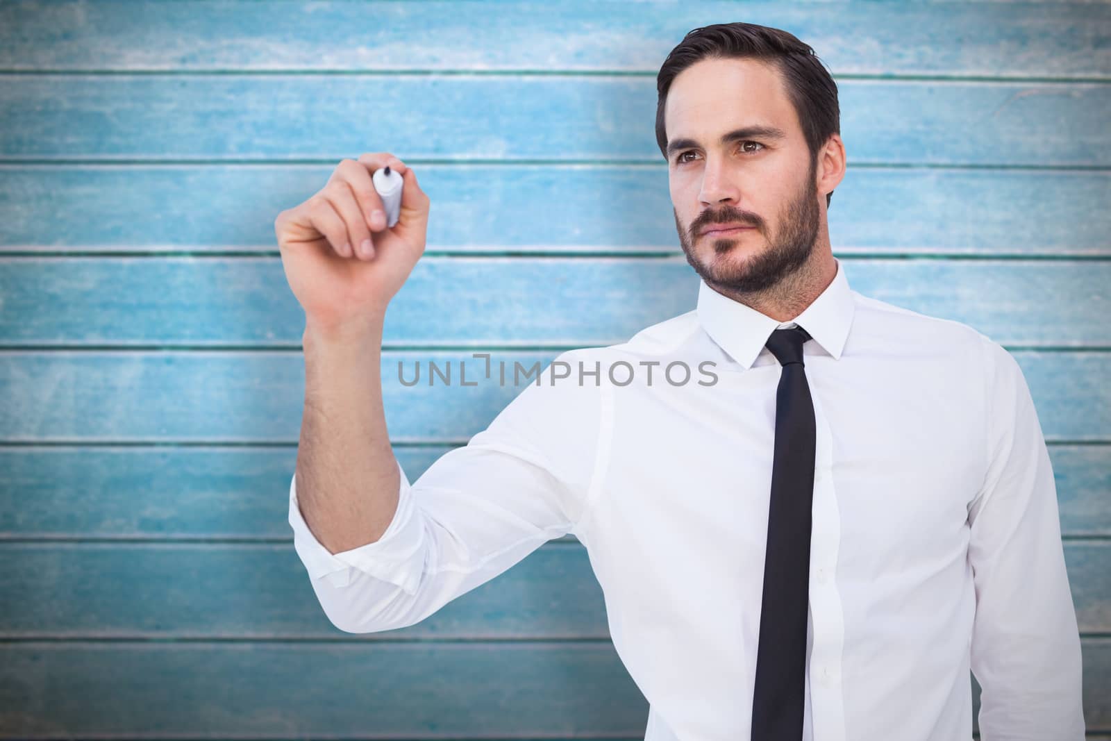 Focused businessman writing with marker against wooden planks