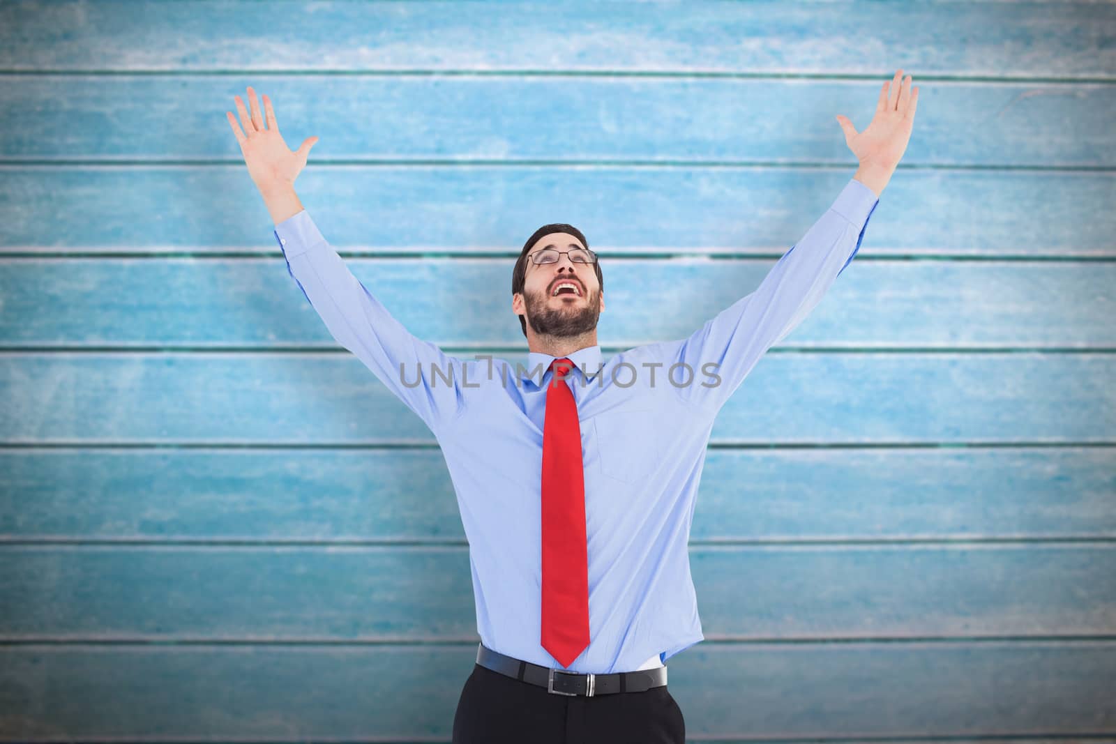 Happy cheering businessman raising his arms against wooden planks