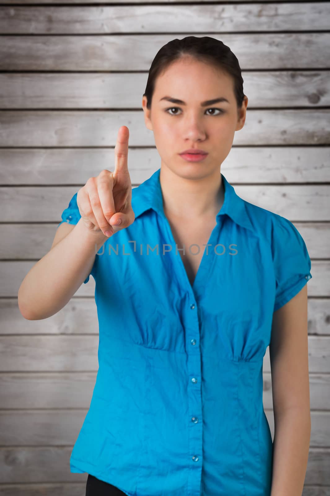 Serious businesswoman pointing against wooden planks