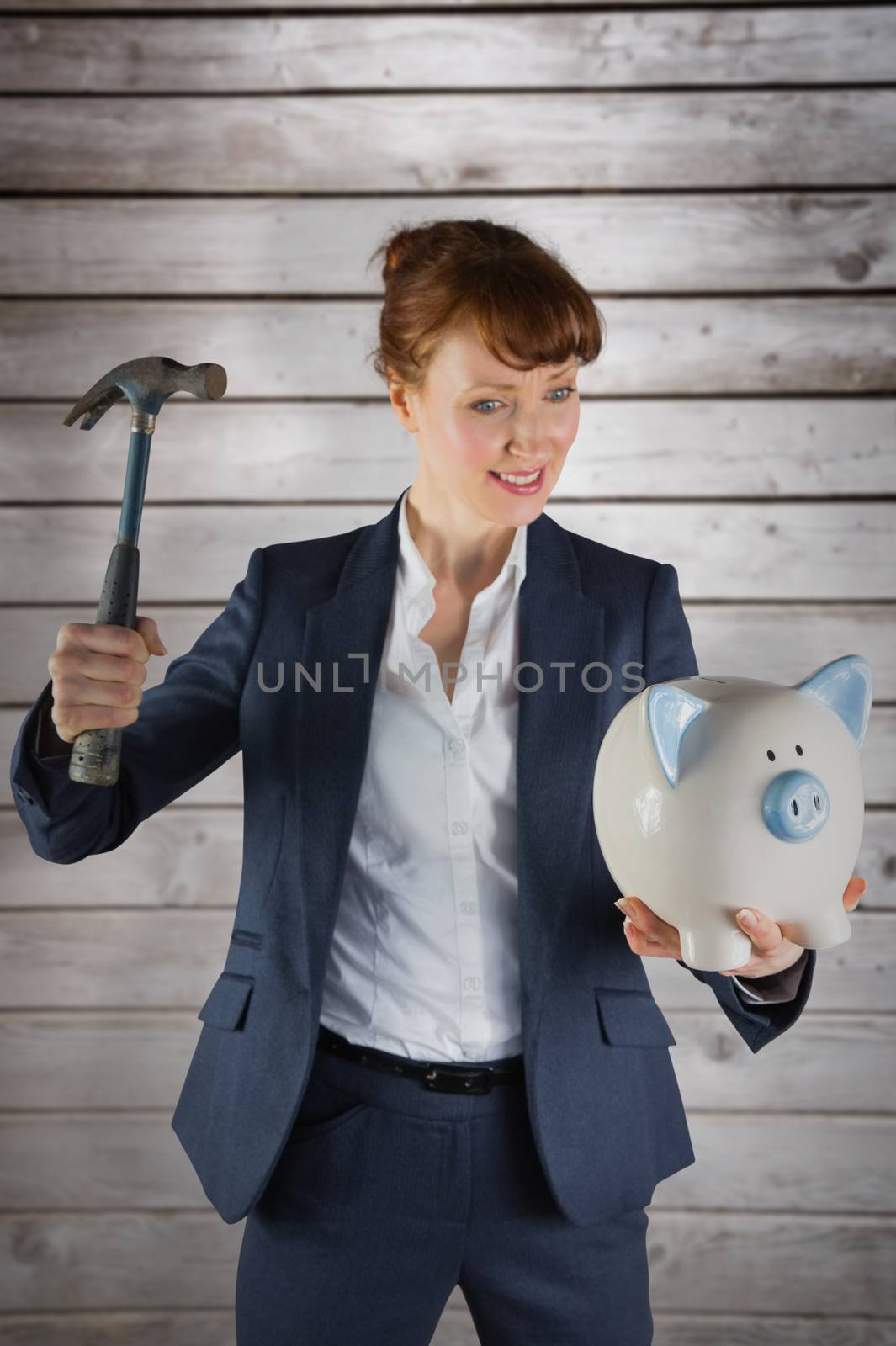 Businesswoman breaking piggy bank against wooden planks