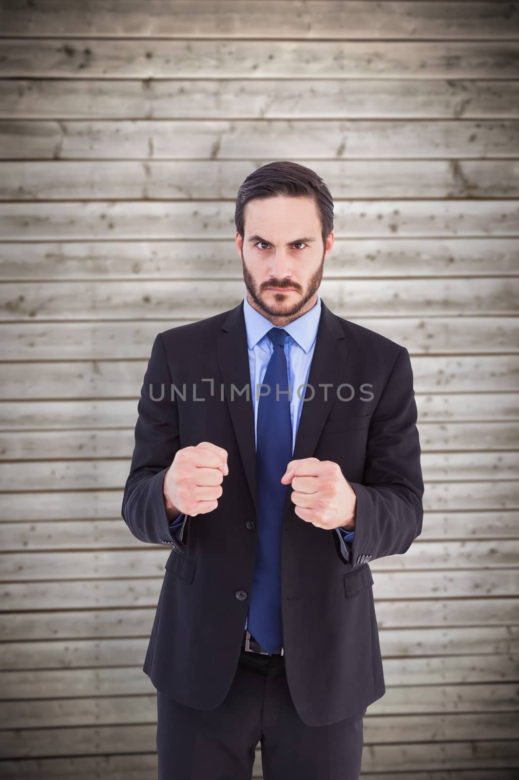 Composite image of angry businessman with closed fists looking at camera by Wavebreakmedia