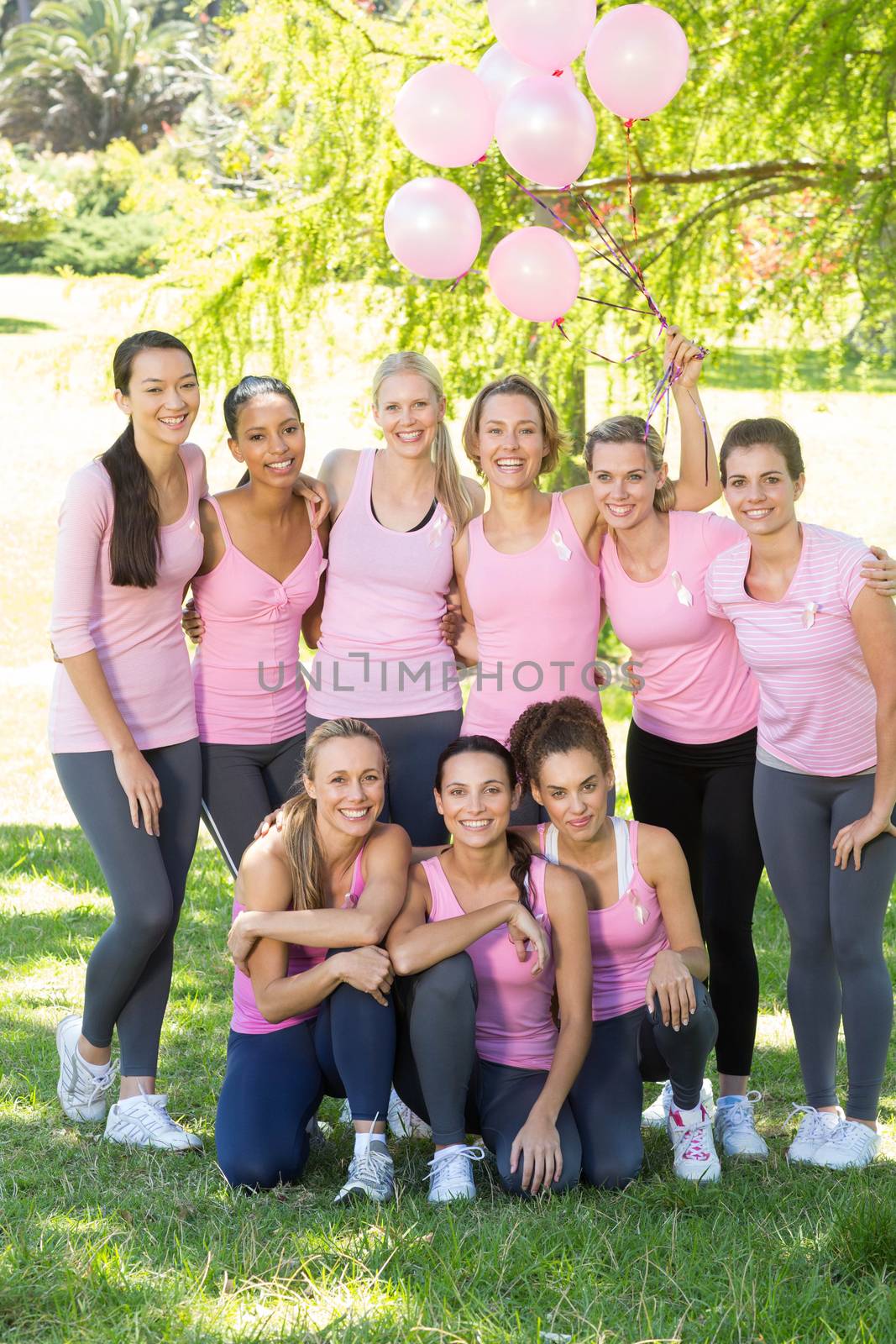 Smiling women in pink for breast cancer awareness by Wavebreakmedia