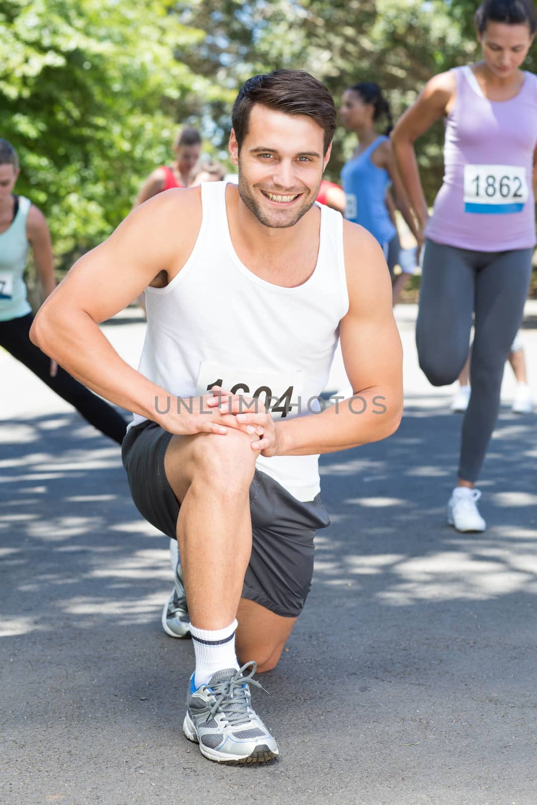 Smiling man warming up before race by Wavebreakmedia