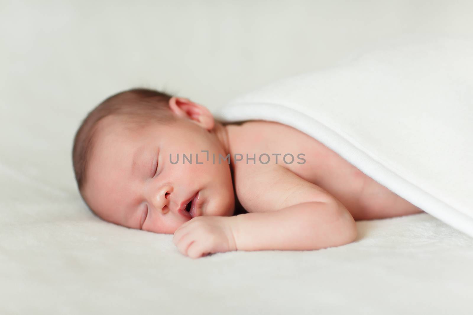 a beautiful sweet newborn baby sleeping on a blanket