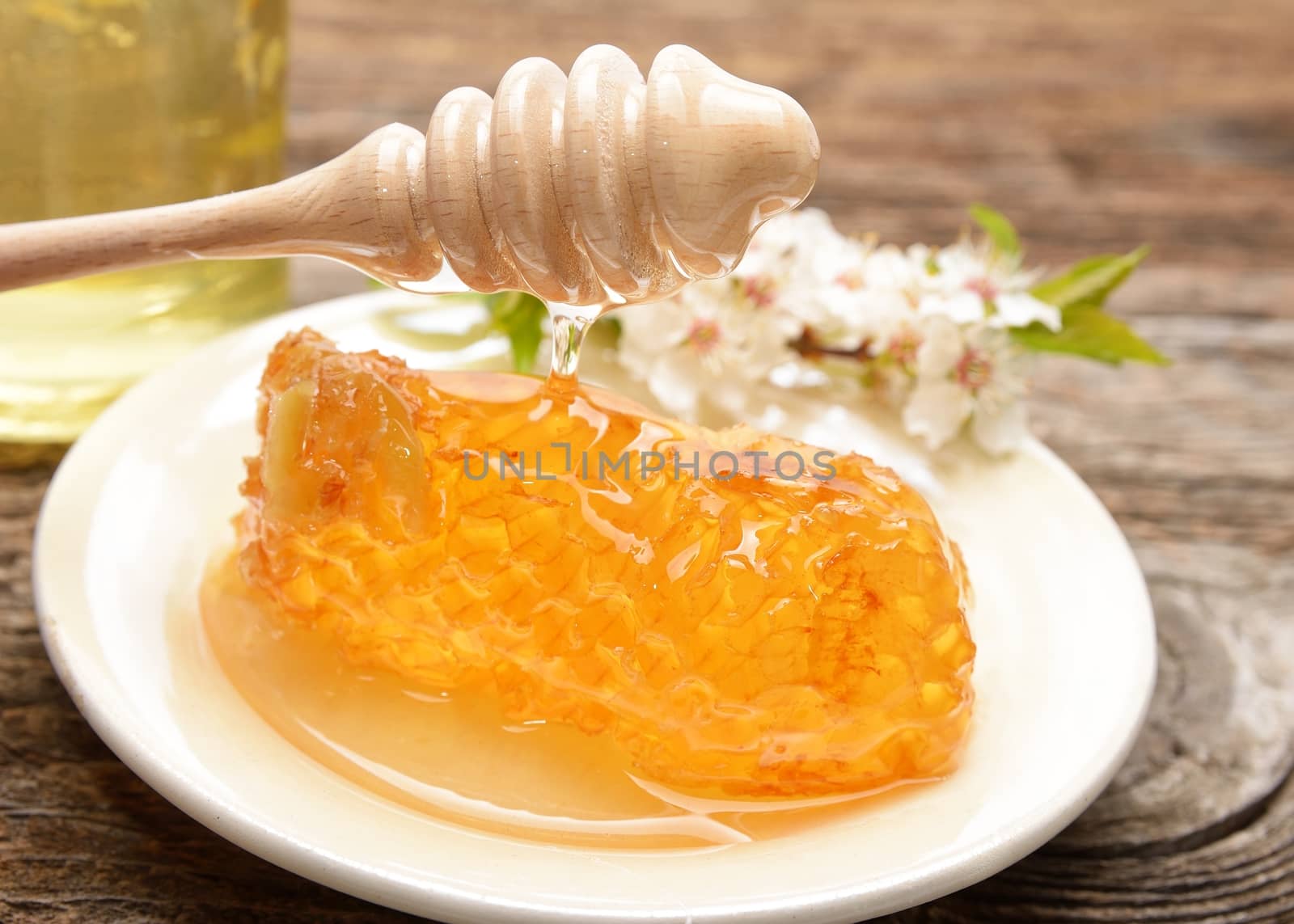 jar of honey with honeycomb on wooden table