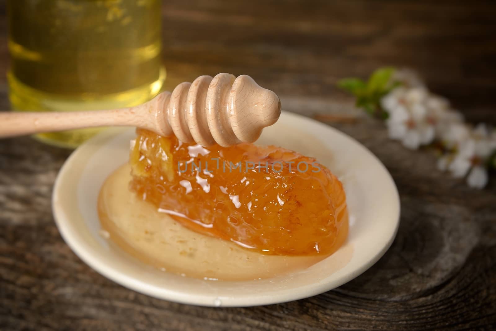 jar of honey with honeycomb on wooden table