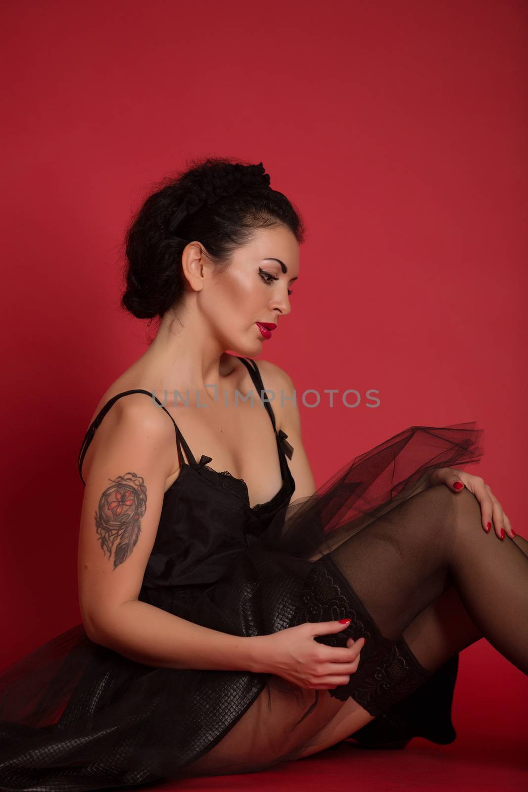 Studio portrait of a sexy brunette in black stockings by sarymsakov