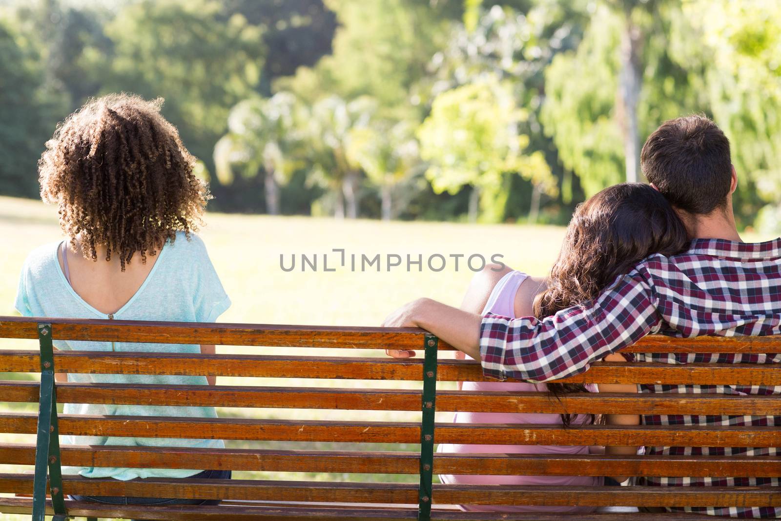 Lonely woman sitting with couple in park by Wavebreakmedia