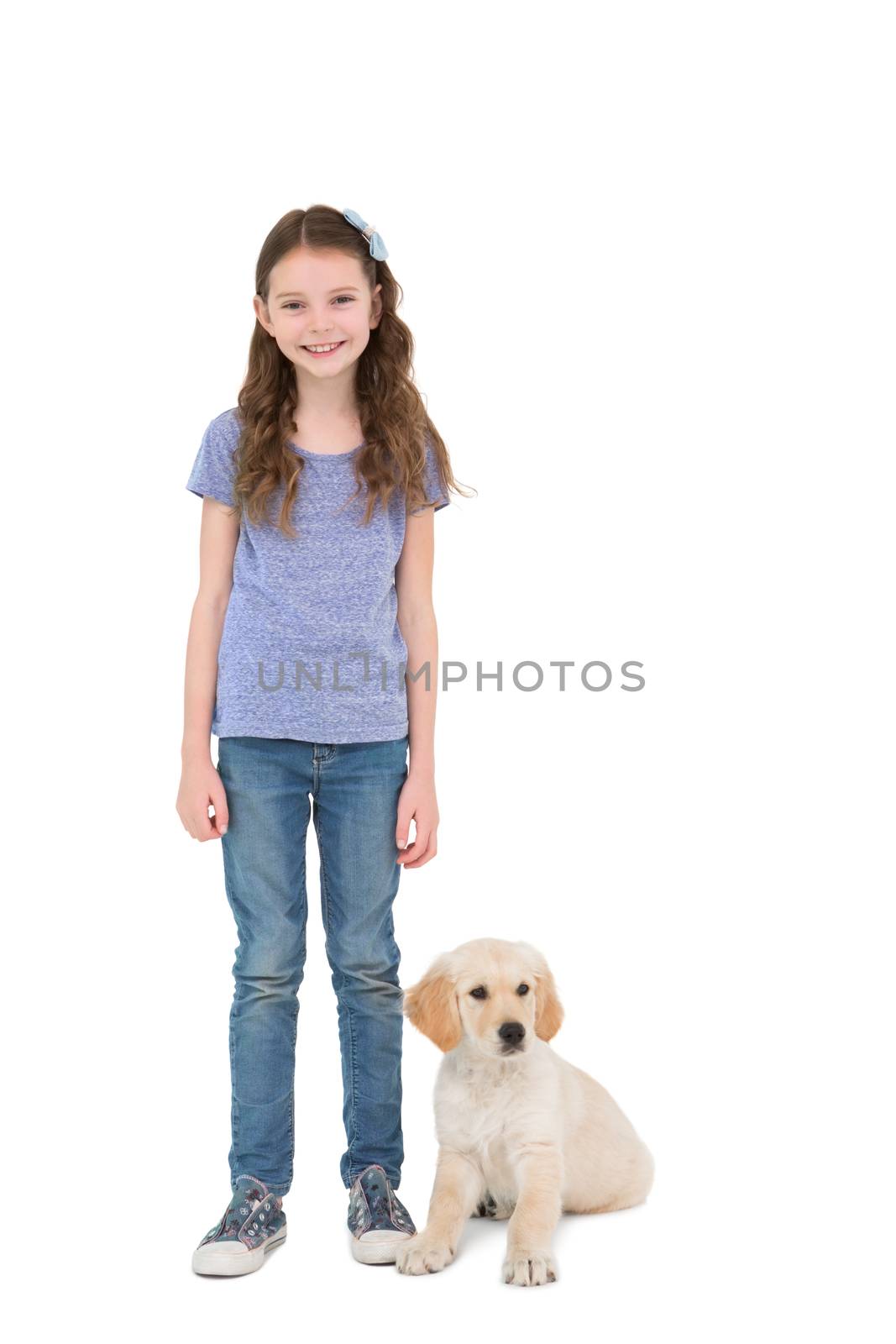 Smiling little girl standing next to dog  by Wavebreakmedia