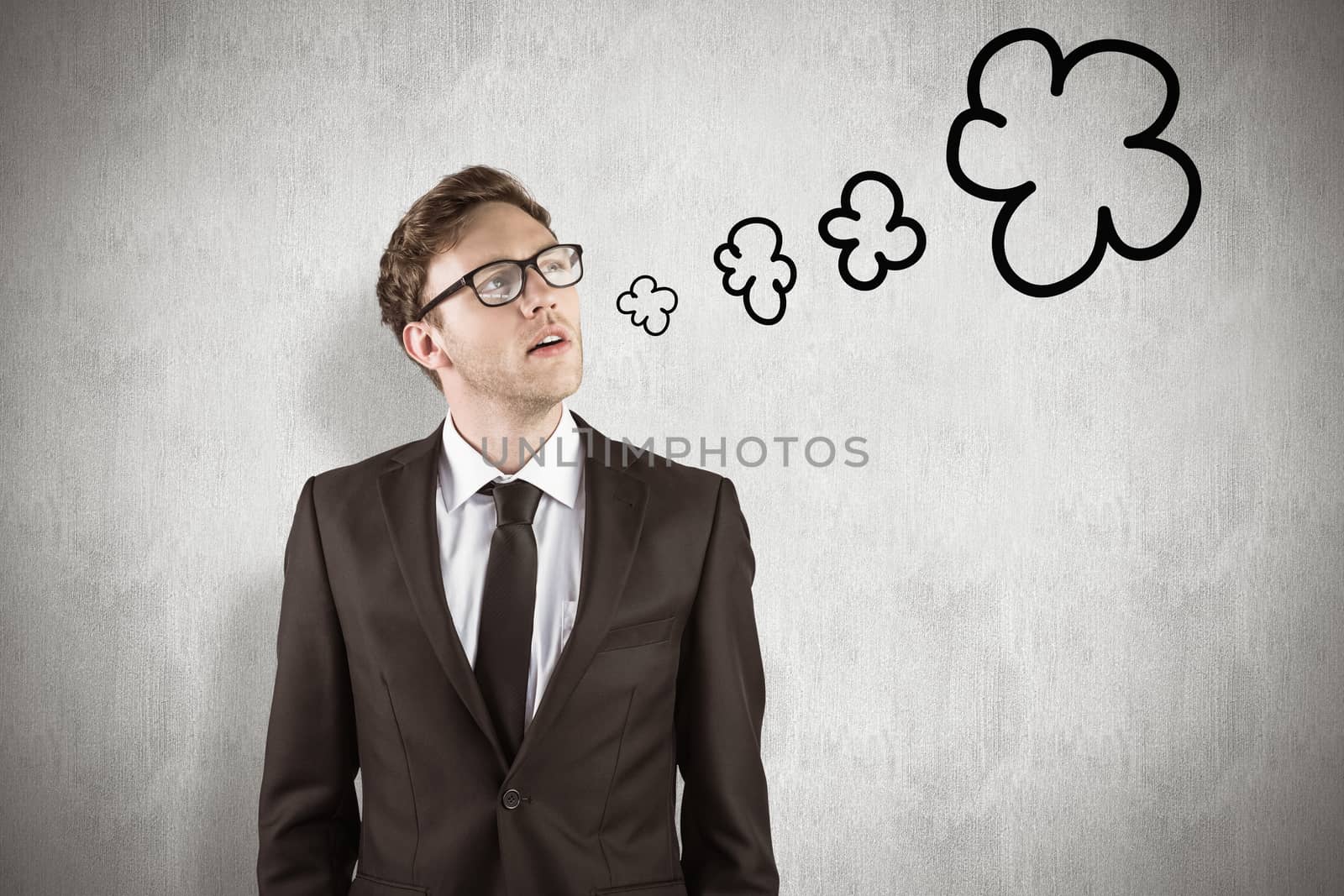 Young businessman thinking and looking up against white background