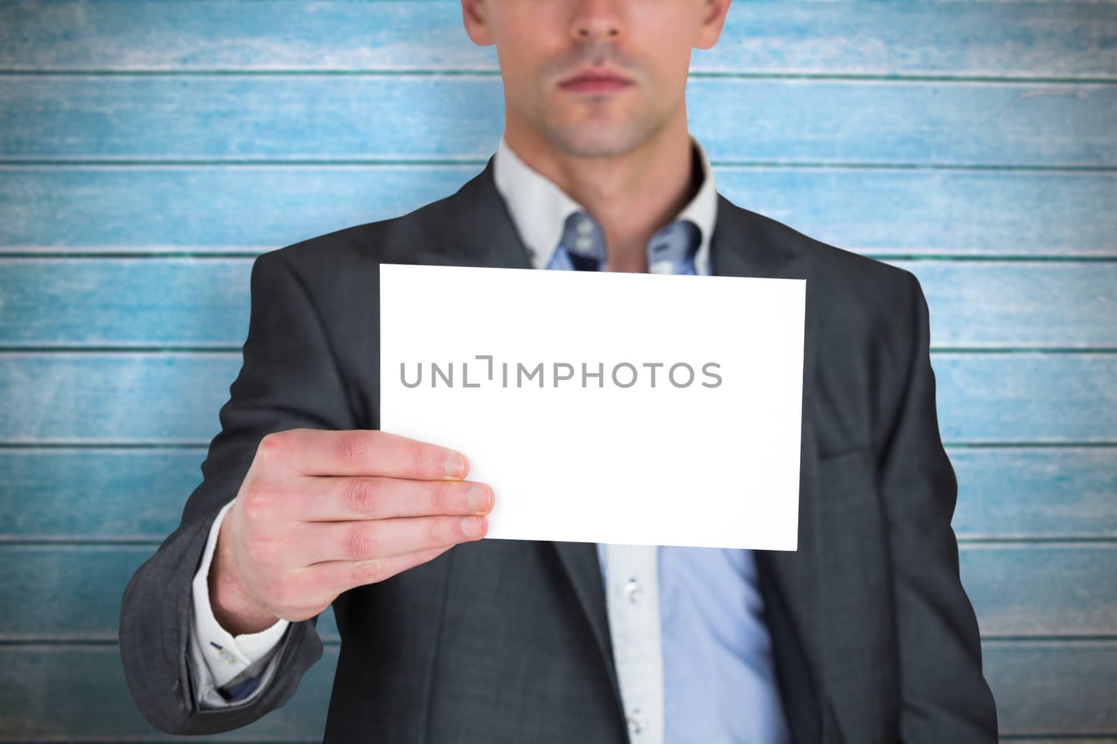 Composite image of businessman in grey suit showing card by Wavebreakmedia