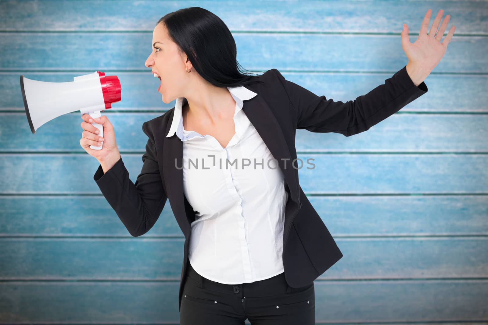 Pretty businesswoman shouting with megaphone against wooden planks