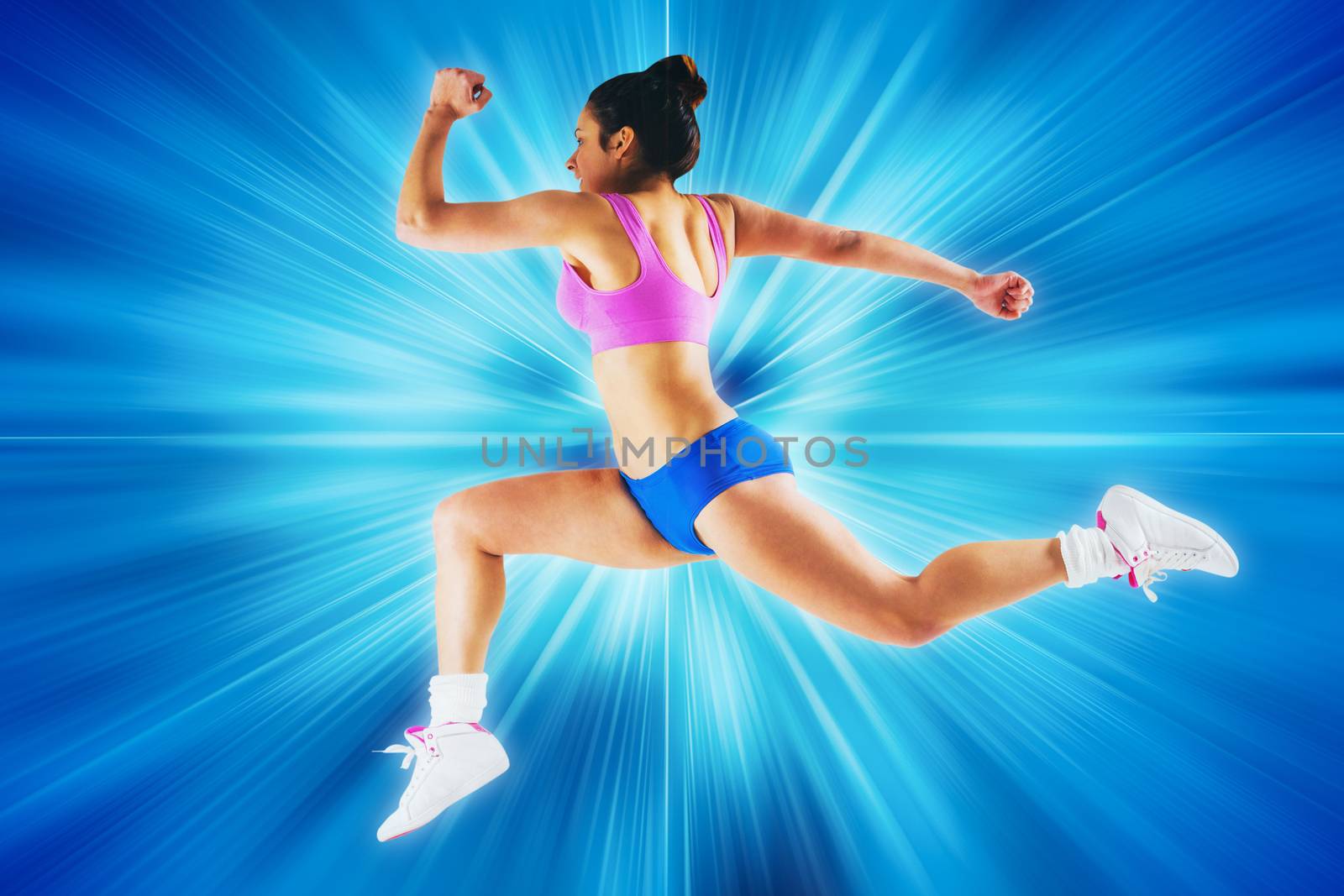 Fit brunette running and jumping against abstract background