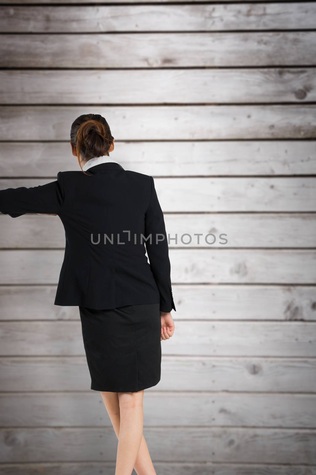 Young businesswoman standing and leaning against wooden planks