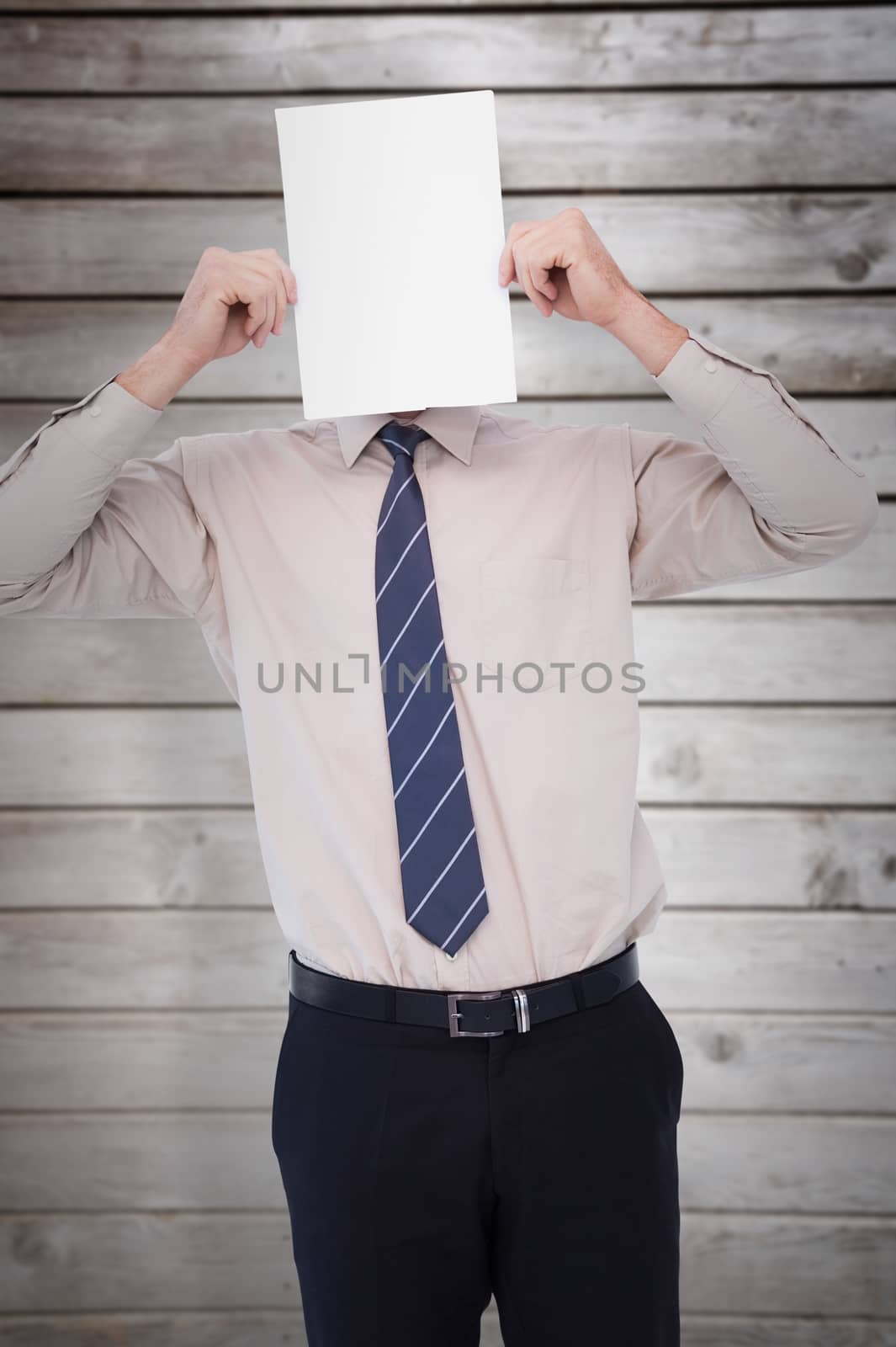 Businessman showing card in front of his head against wooden planks
