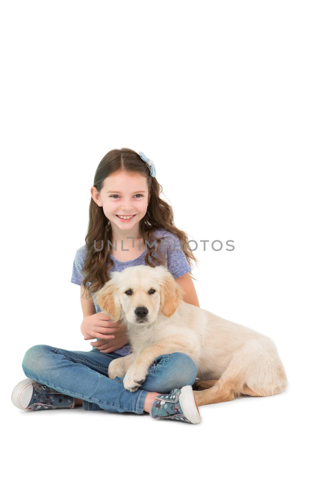 Happy little girl sitting with dog on her legs by Wavebreakmedia