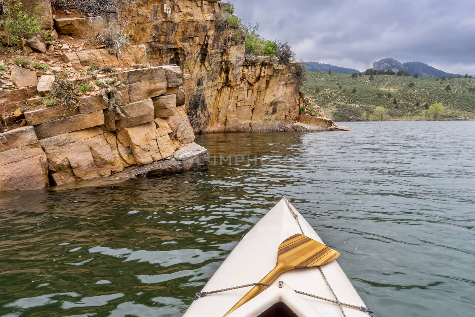 canoe and sandstone cliff by PixelsAway