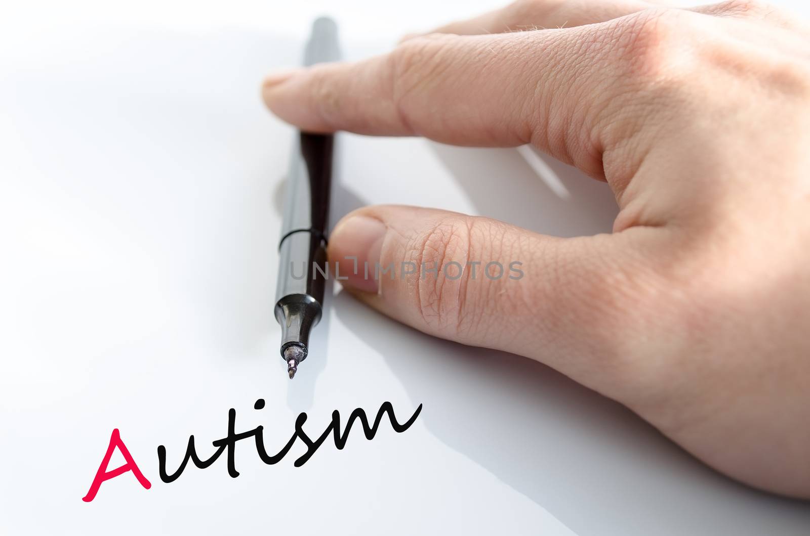 Pen in the hand isolated over white background autism concept