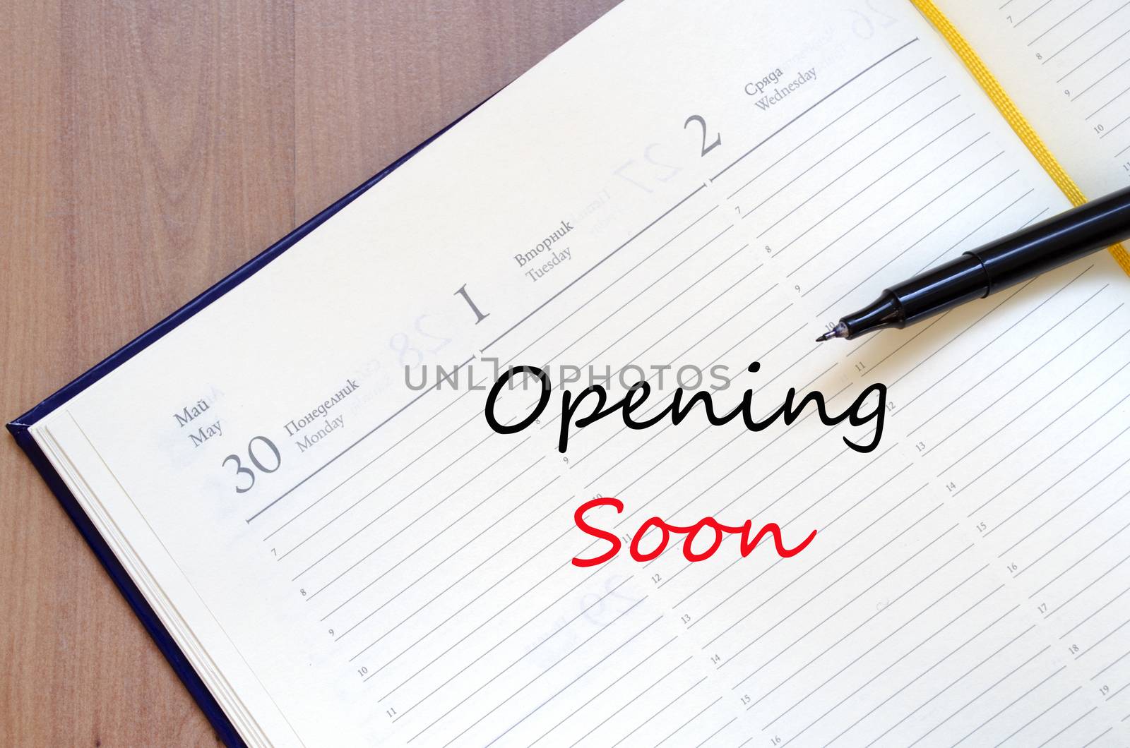 Yellow blank notepad on office wooden table Opening Soon Concept