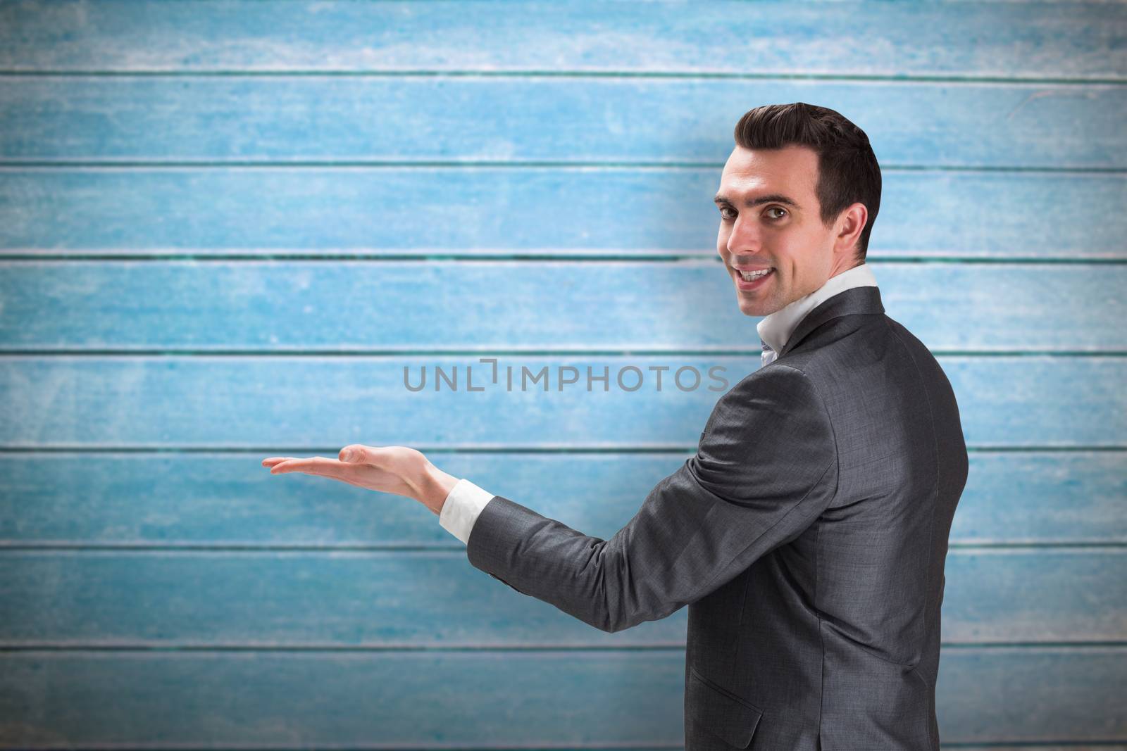 Businessman presenting with hand against wooden planks