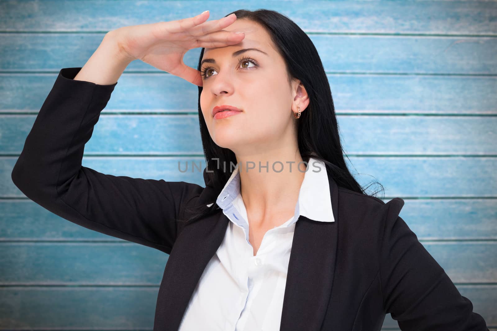 Pretty businesswoman looking with hand up against wooden planks