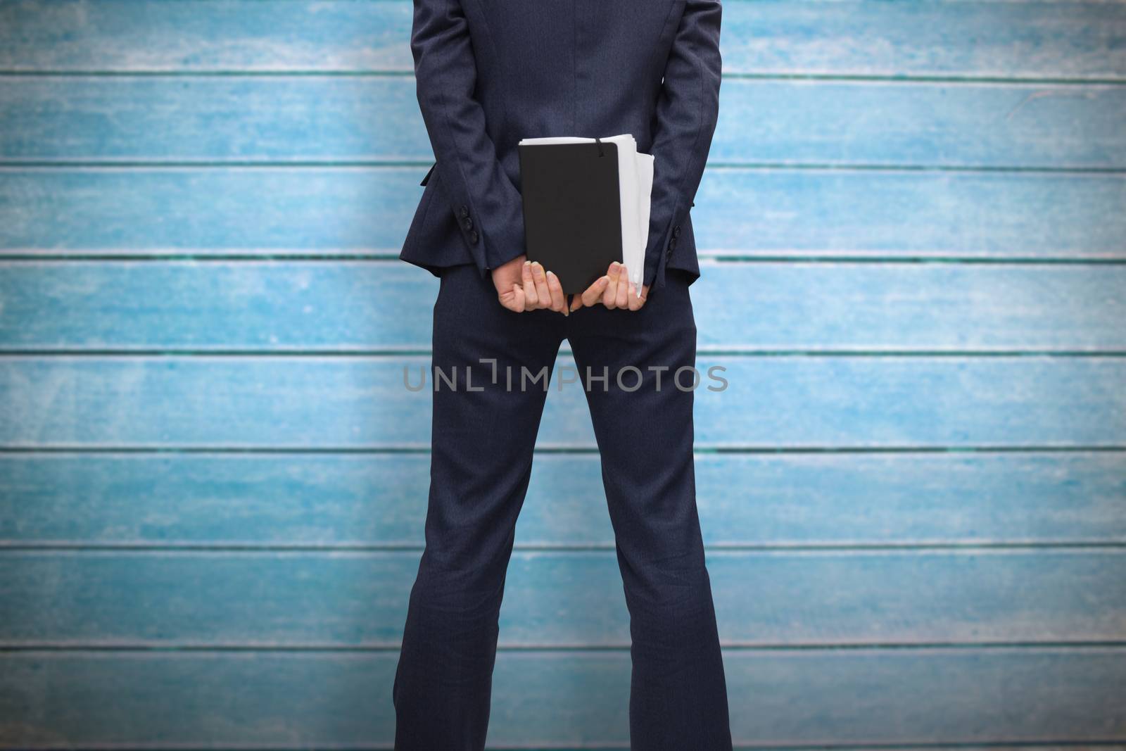 Businesswoman holding diary against wooden planks