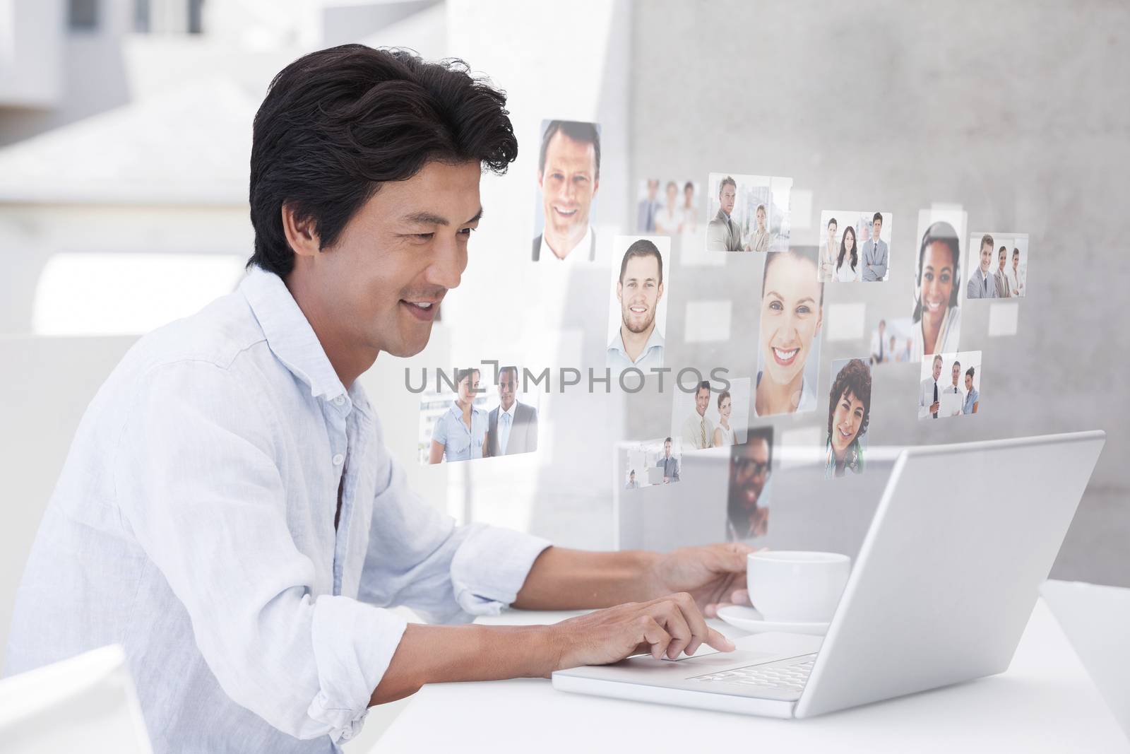 Happy man using laptop while having a coffee against business people