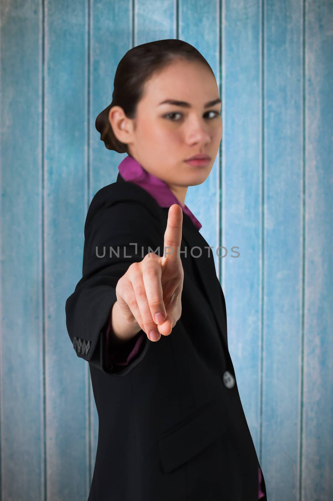 Serious businesswoman pointing against wooden planks