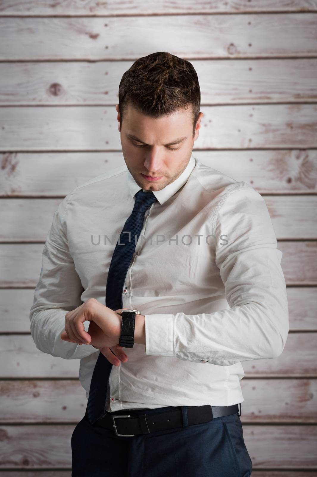 Handsome businessman checking the time against wooden planks