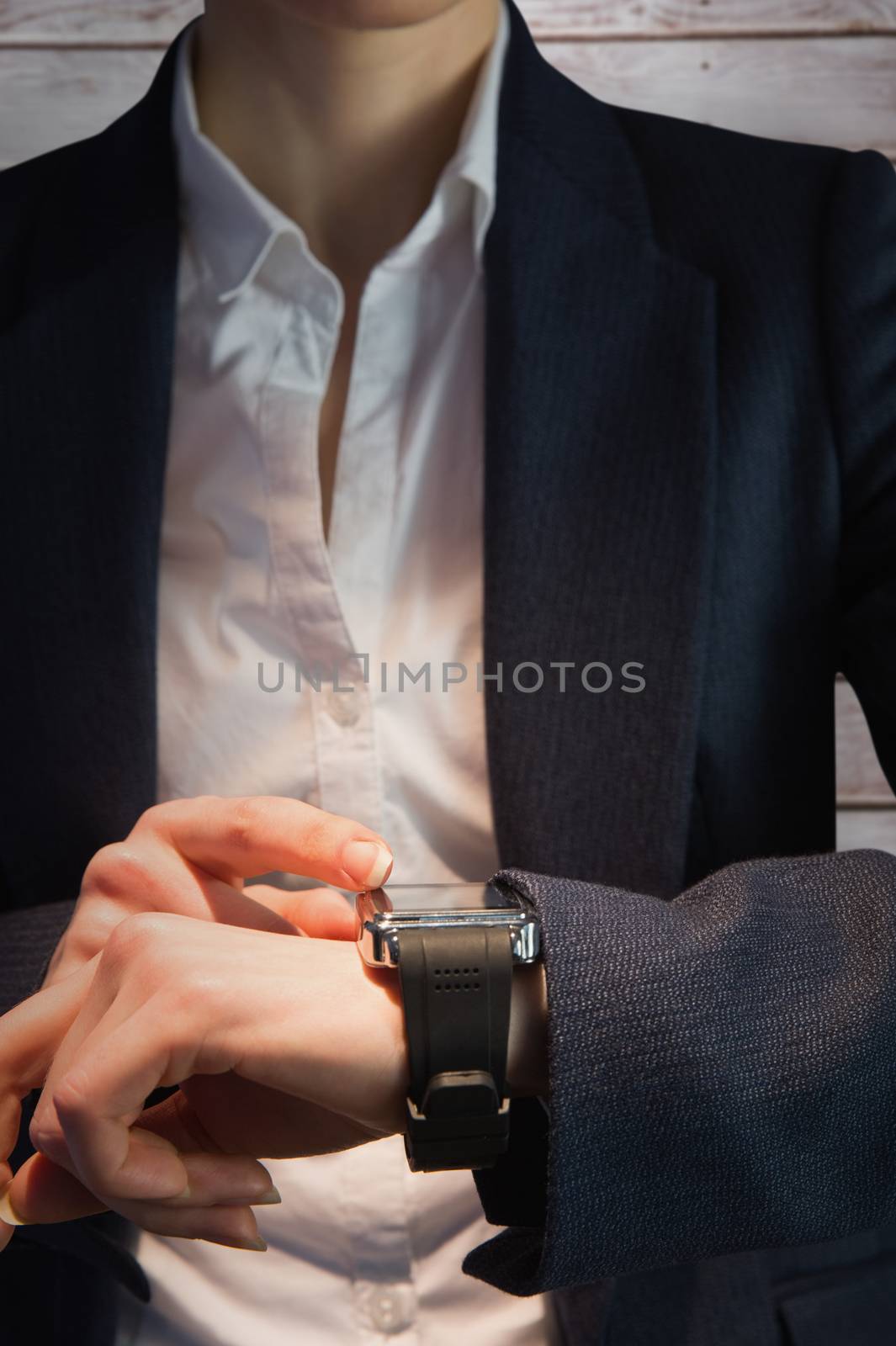 Businesswoman with watch against wooden planks