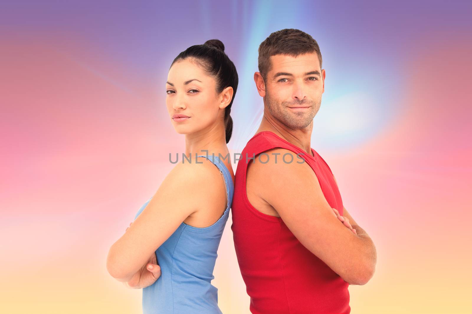 Fit man and woman smiling at camera together against abstract background