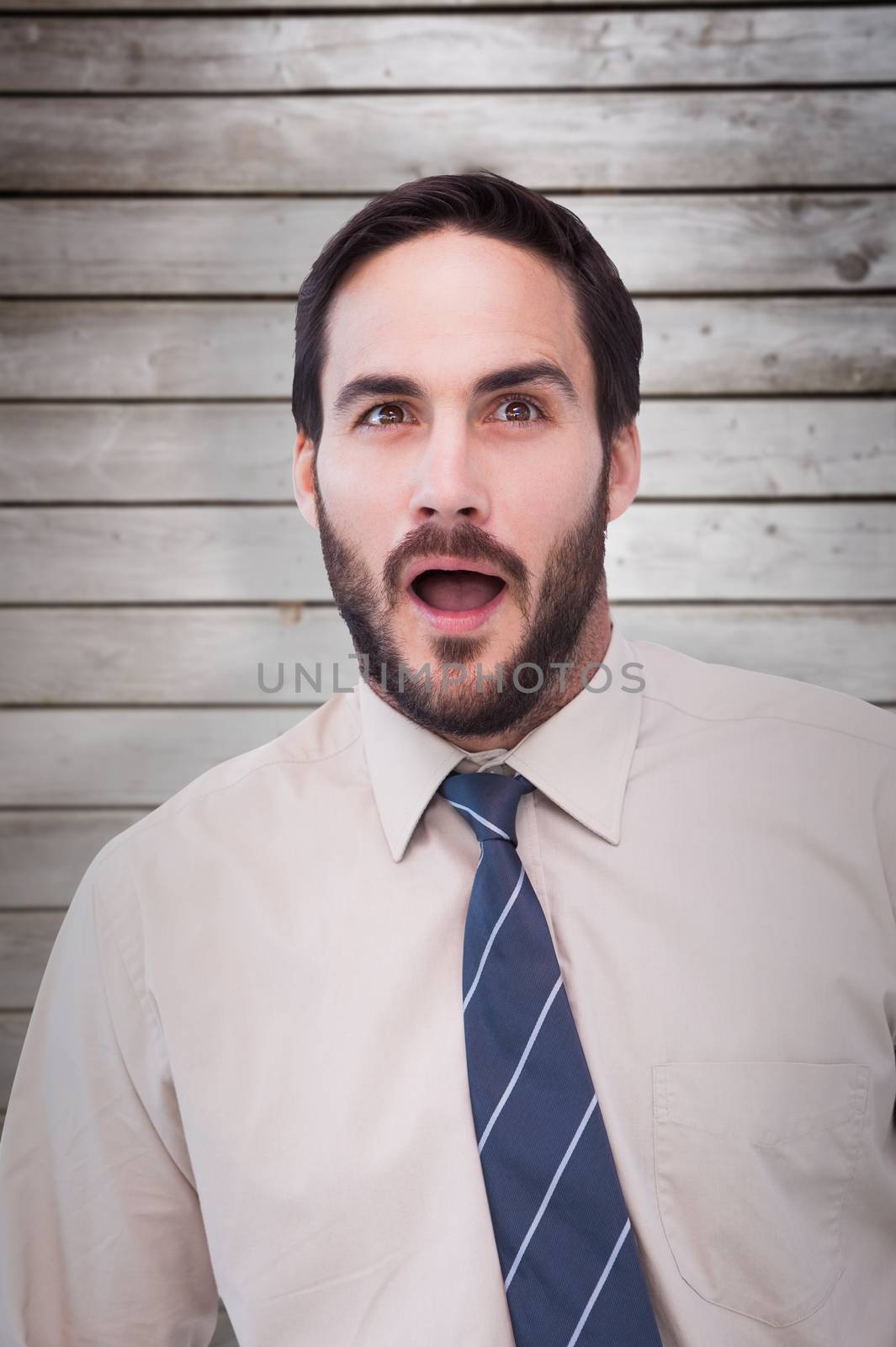 Portrait of shocked businessman with mouth open against wooden planks