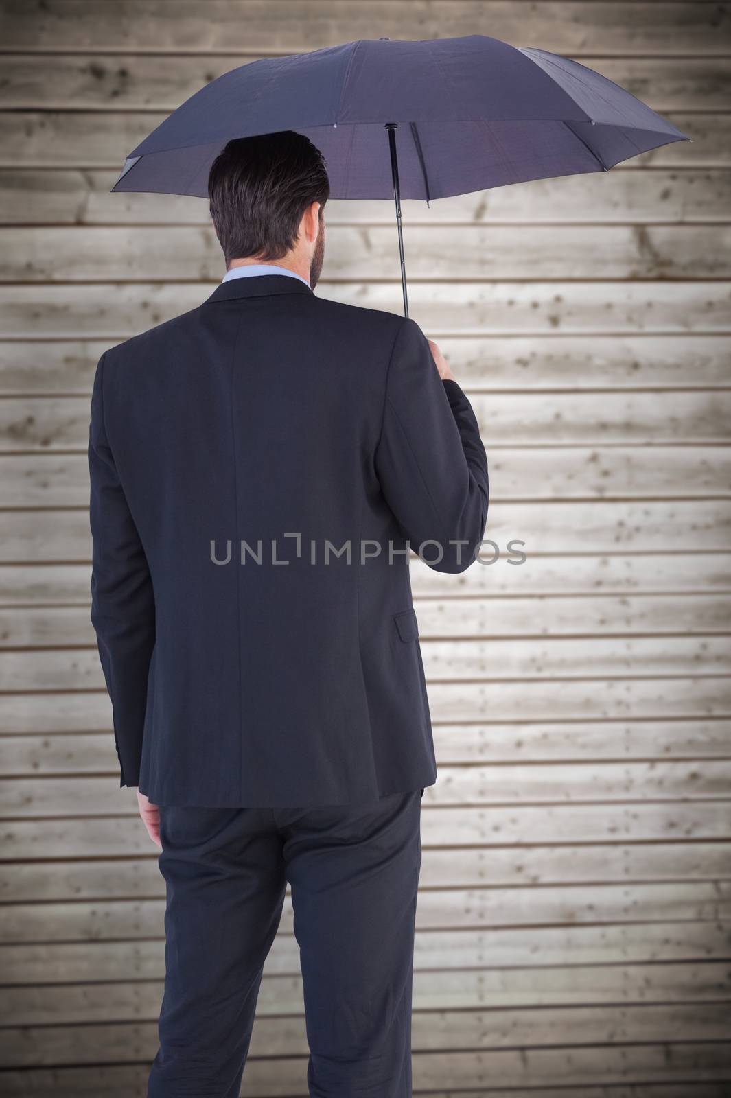 Businesswoman in suit holding umbrella against wooden planks background